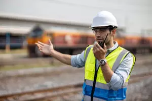Un homme travaillant en extérieur parlant au talkie walkie
